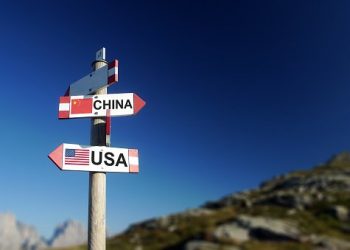 Chinese and American flags in two directions on road sign. Relationships and differences in diplomacy, strategy and interests.